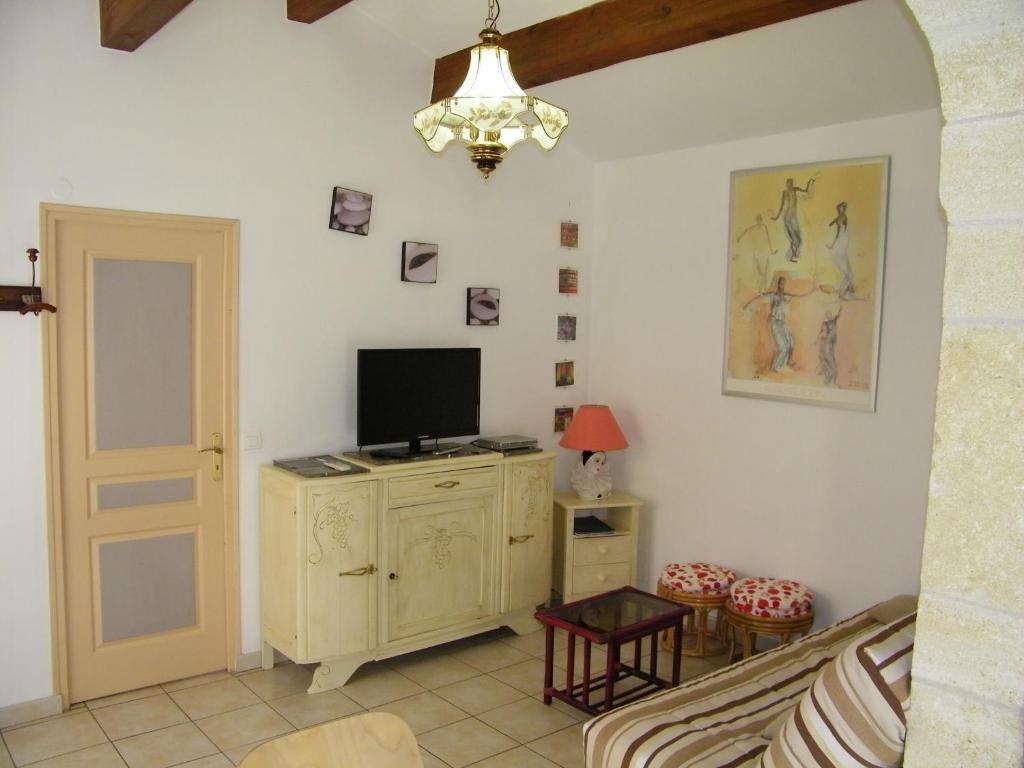 un salon avec une télévision sur un meuble dans l'établissement Domaine du bois gîte Bleuette, à Galargues
