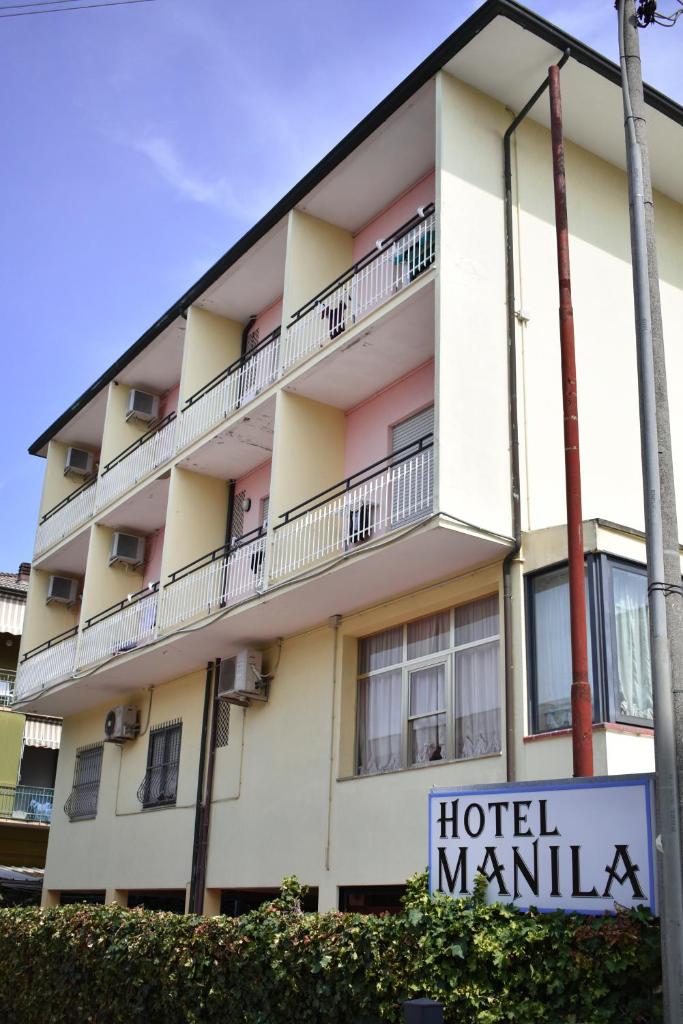un bâtiment manilla avec un panneau devant lui dans l'établissement Hotel Manila, à Cervia
