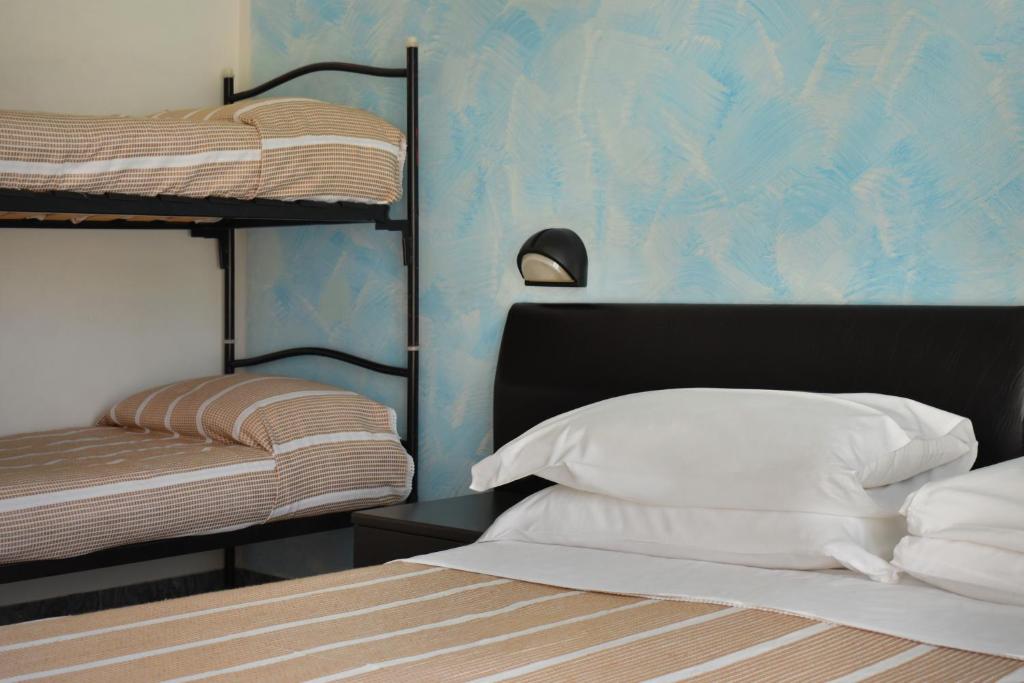 - une chambre avec deux lits superposés et un lit avec des oreillers blancs dans l'établissement Hotel Manila, à Cervia 56 autres photos