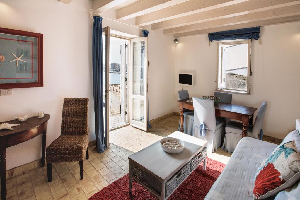 - un salon avec un canapé, une table et un piano dans l'établissement Musciara Siracusa Resort, à Syracuse