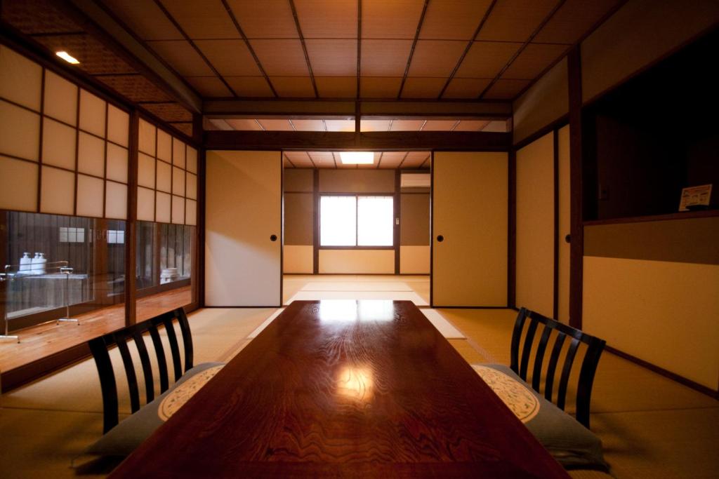 Cette chambre comprend une grande table et des chaises en bois. dans l'établissement Yufuin Gettouan, à Yufu