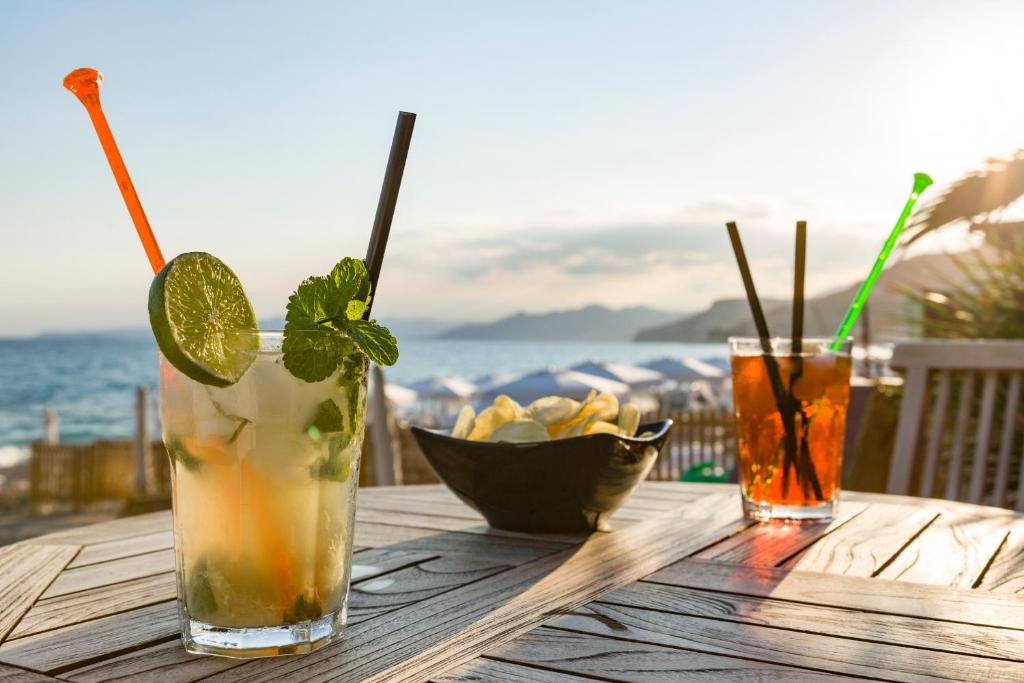 deux boissons sur une table en bois avec vue sur l'océan dans l'établissement Miramare di Varigotti, à Varigotti