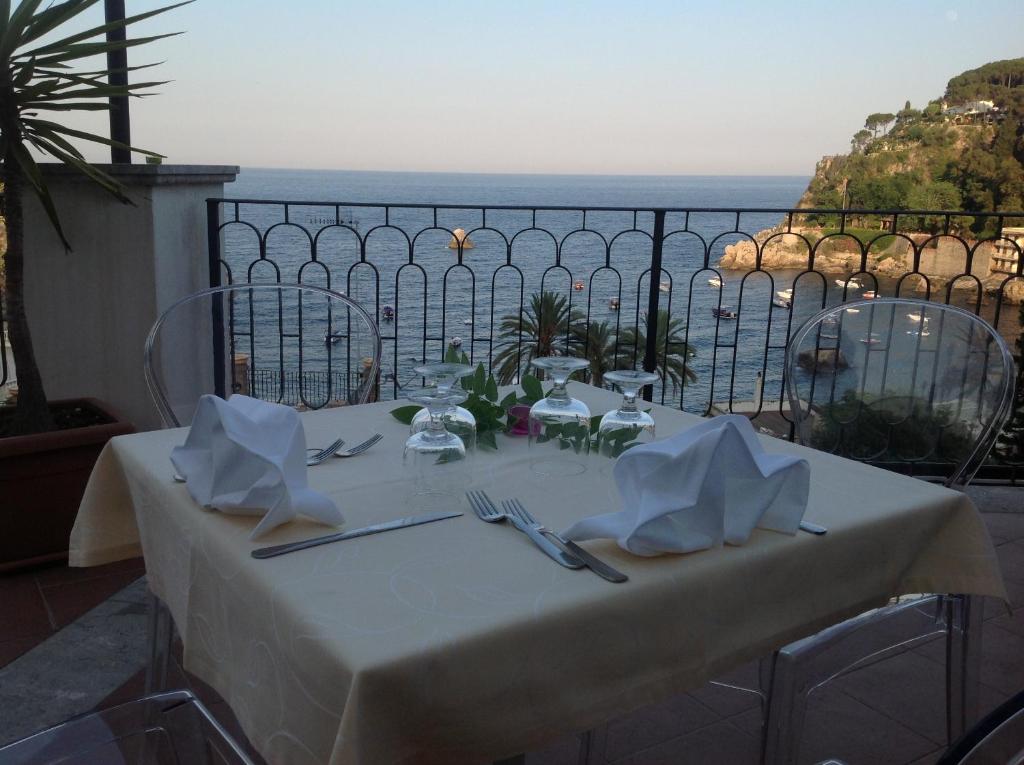 - une table blanche avec vue sur l'océan dans l'établissement Hotel Baia Azzurra, à Taormine