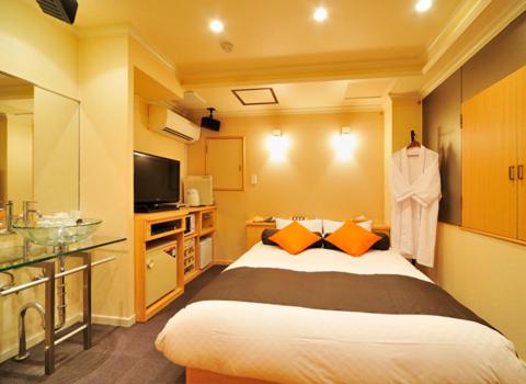 une chambre d'hôtel avec un lit et une télévision dans l'établissement Hotel California Kaminarimon (Adult Only), à Tokyo 11 autres photos