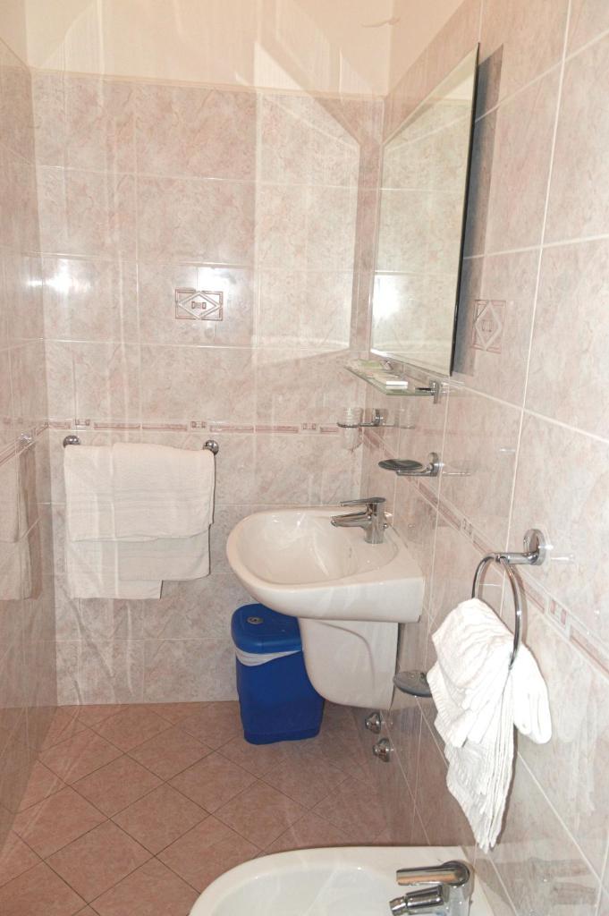 une salle de bain avec un lavabo, des toilettes et un miroir dans l'établissement Hotel Karin, à Rimini 61 autres photos