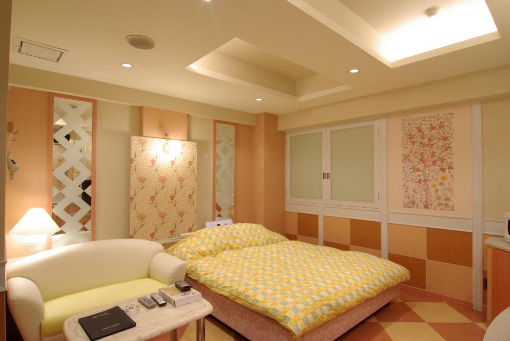une chambre avec un lit, un canapé et une chaise dans l'établissement Shonan Sirene (Adult Only), à Hiratsuka