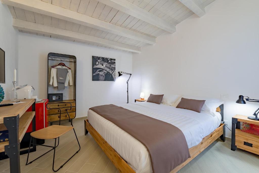 - une chambre avec un grand lit et un bureau dans l'établissement Le Maestranze Deluxe Rooms, à Sciacca