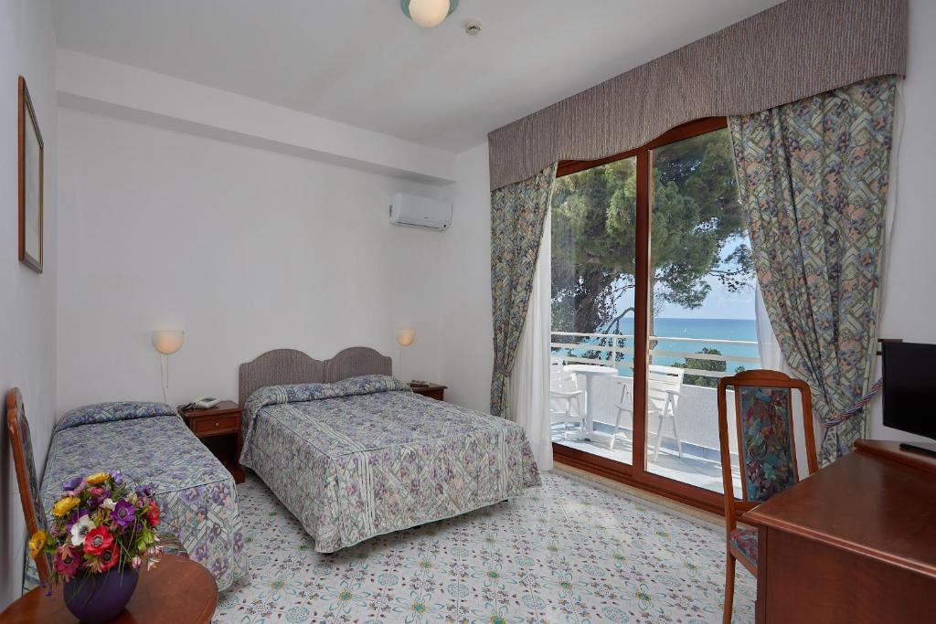 Cet appartement comprend une chambre avec deux lits et un balcon donnant sur l'océan. dans l'établissement Hotel La Castellana, à Belvedere Marittimo