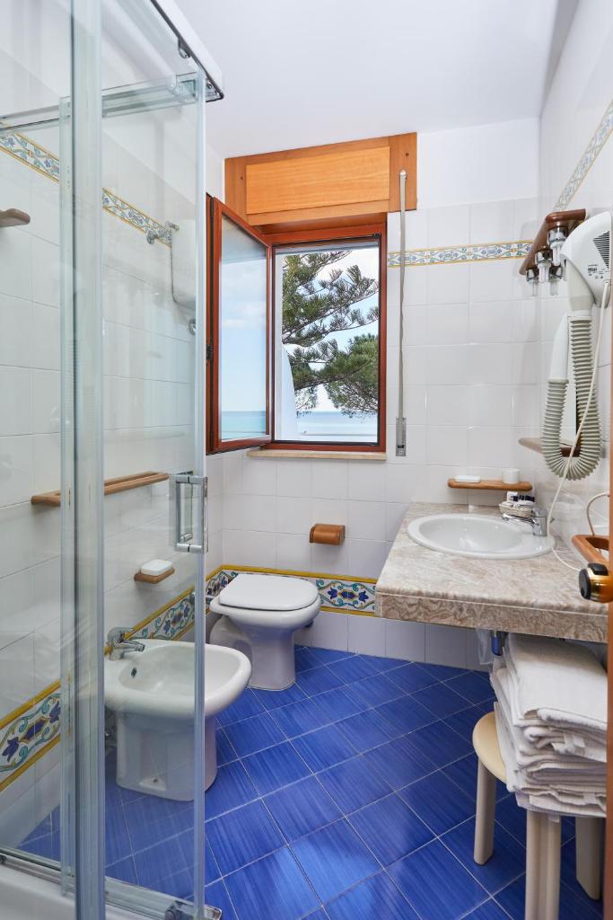 une salle de bain avec toilettes, lavabo et douche dans l'établissement Hotel La Castellana, à Belvedere Marittimo