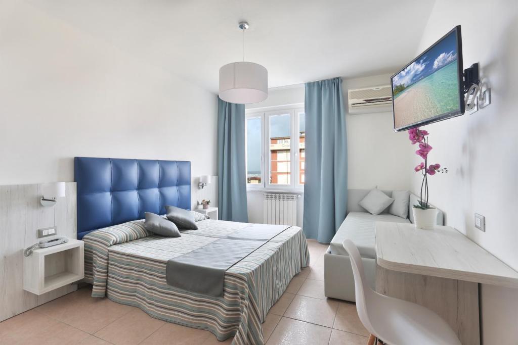 une chambre avec un lit et une télévision dans l'établissement Hotel Nuovo Tirreno, à Lido di Camaiore
