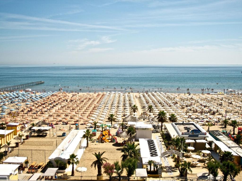 - une plage avec de nombreux parasols et l'océan dans l'établissement Hotel Kursaal, à Rimini