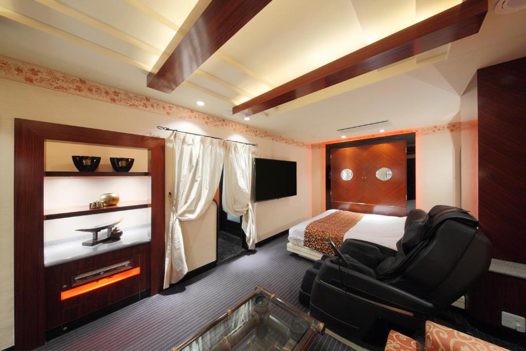 une chambre d'hôtel avec un lit et une chaise dans l'établissement Hotel Cherena Kunitachi (Adult Only), à Kunitachi