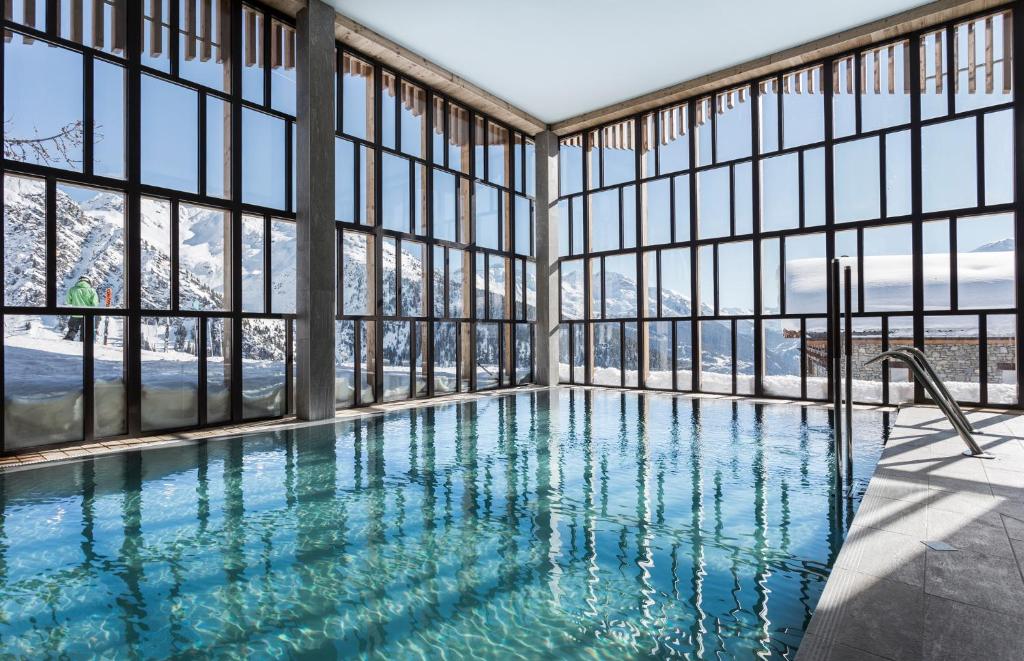 - une piscine avec fenêtres et vue sur la montagne dans l'établissement Hôtel Alparena & Spa - 4 étoiles, à La Rosière