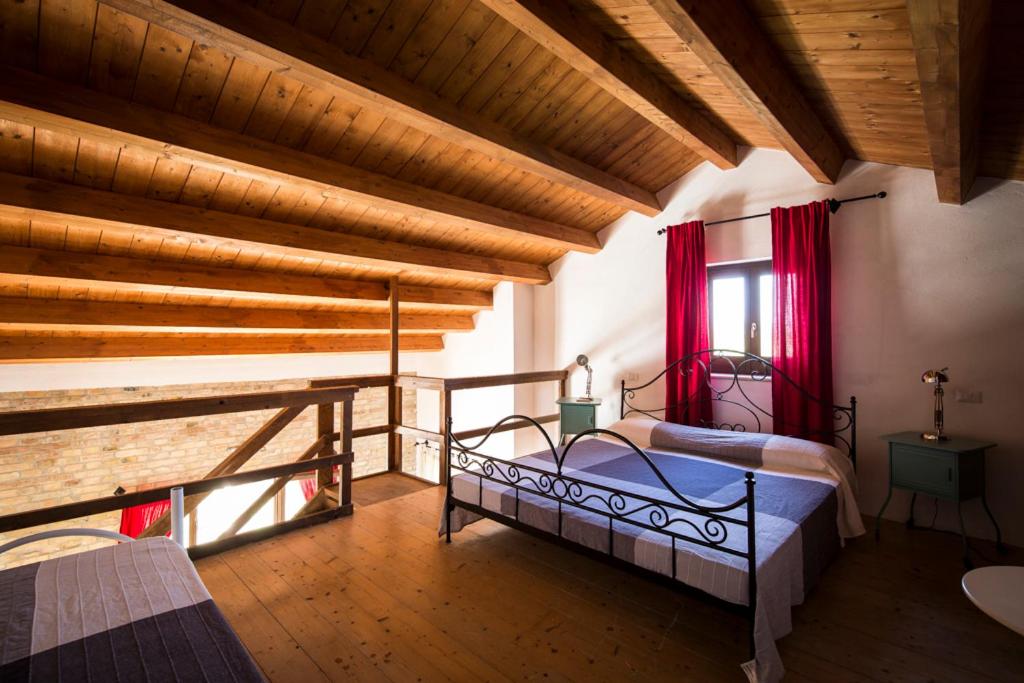 une chambre avec un lit dans une pièce avec des plafonds en bois dans l'établissement Casali Costadoro, à Acquaviva Picena