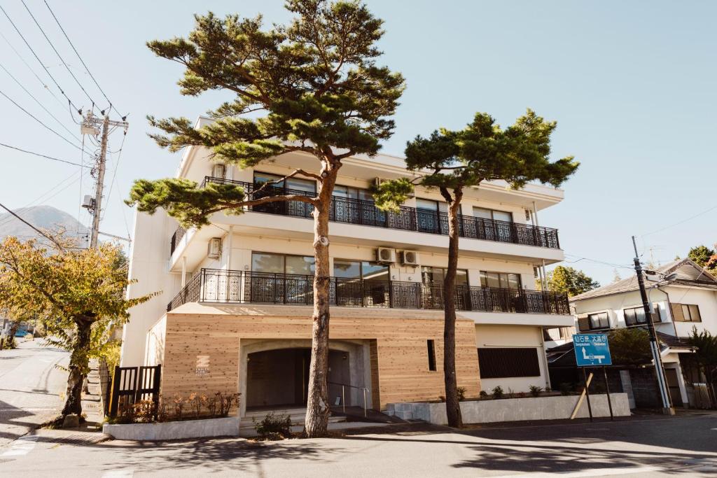 un bâtiment avec deux arbres devant lui dans l'établissement WPÜ HOTEL HAKONE, à Hakone