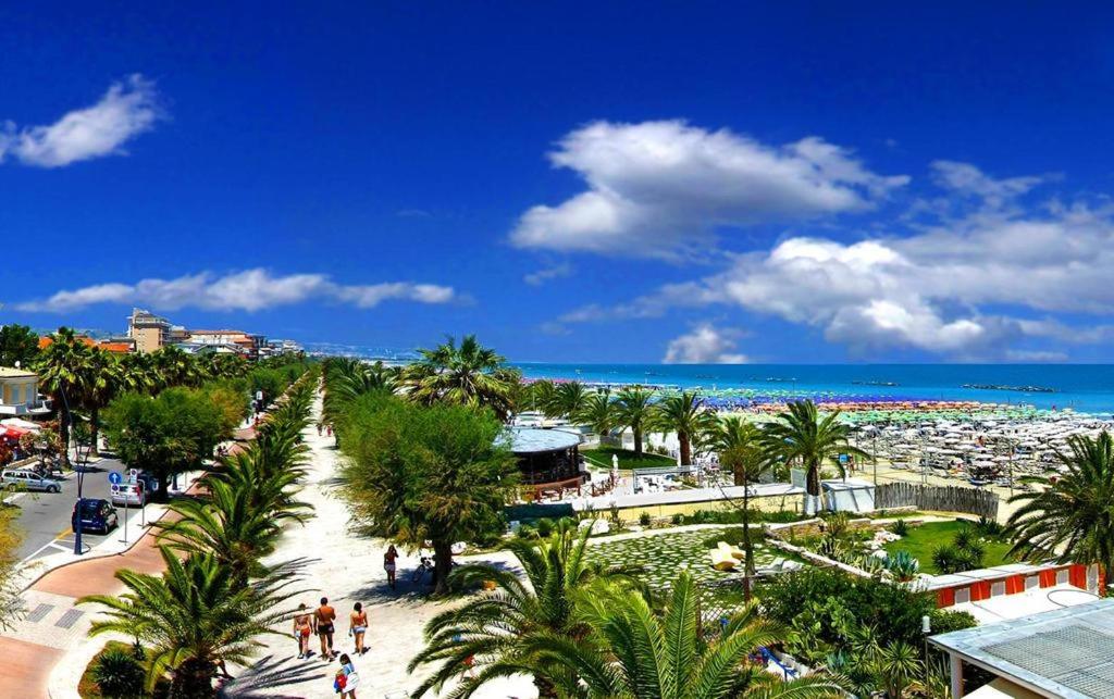 une vue sur une plage avec des palmiers et l'océan dans l'établissement Hotel Royal, à San Benedetto del Tronto