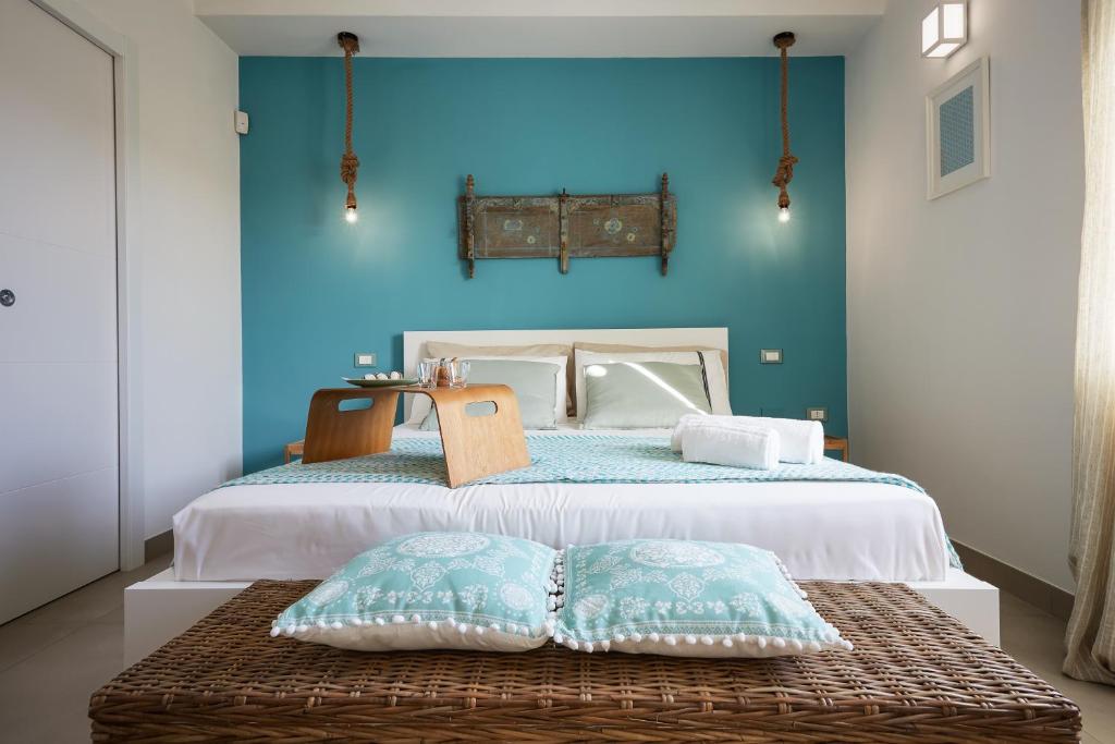 une chambre avec un lit avec un mur bleu dans l'établissement Sariva Villa CaseSicule - heated Pool, Beach at 50 m, à Ispica