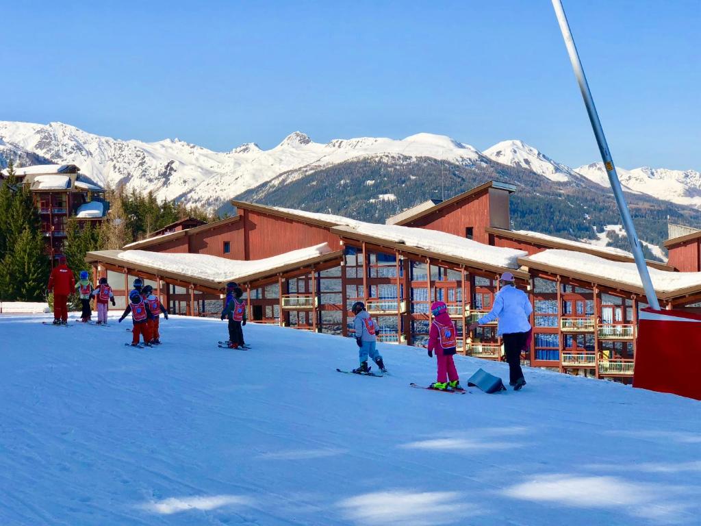 un groupe de personnes debout dans la neige devant un lodge de ski dans l'établissement Arcadien - Appartement les Arcs 1800 - 10 personnes - 3 chambres, à Arc 1800
