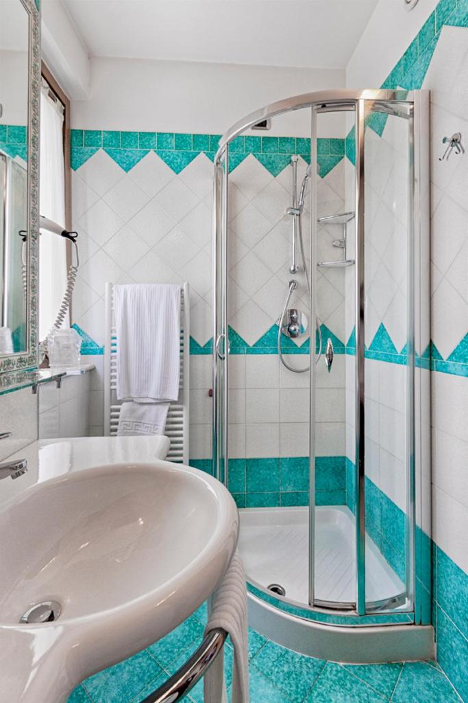 une salle de bain avec un lavabo et une douche dans l'établissement Villa Luigi Hotel & Restaurant Nuova gestione, à Martinsicuro