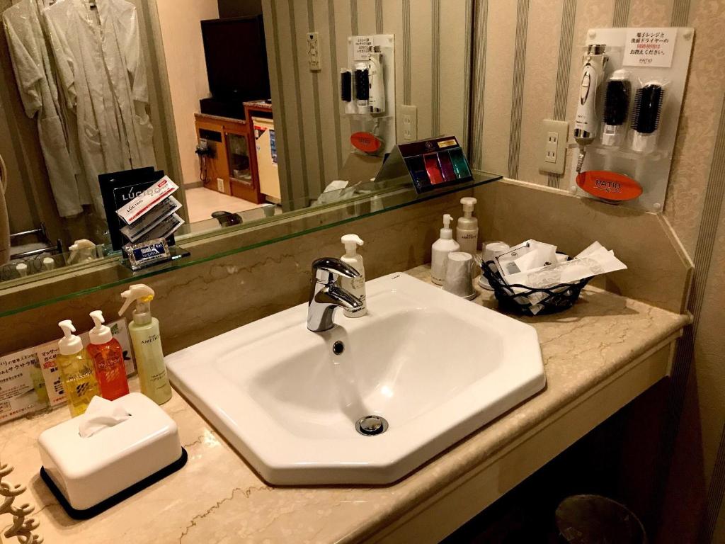 un comptoir de salle de bain avec un lavabo et un miroir dans l'établissement Hotel Patio Ise (Adult Only), à Ise