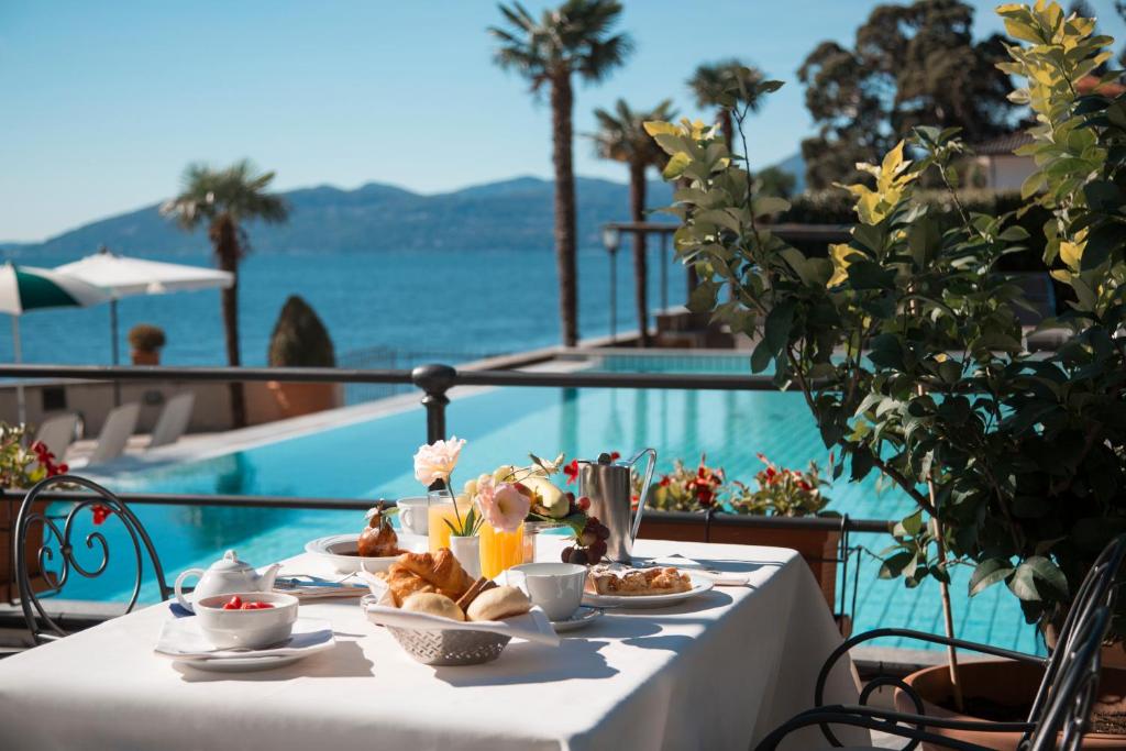 une table avec de la nourriture dessus à côté d'une piscine dans l'établissement Hotel Ghiffa, à Ghiffa