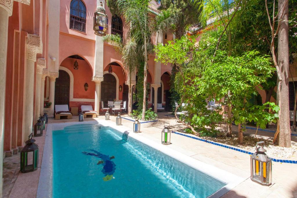 une piscine dans la cour d'un immeuble dans l'établissement Riad Le Perroquet Bleu Suites & Spa, à Marrakech