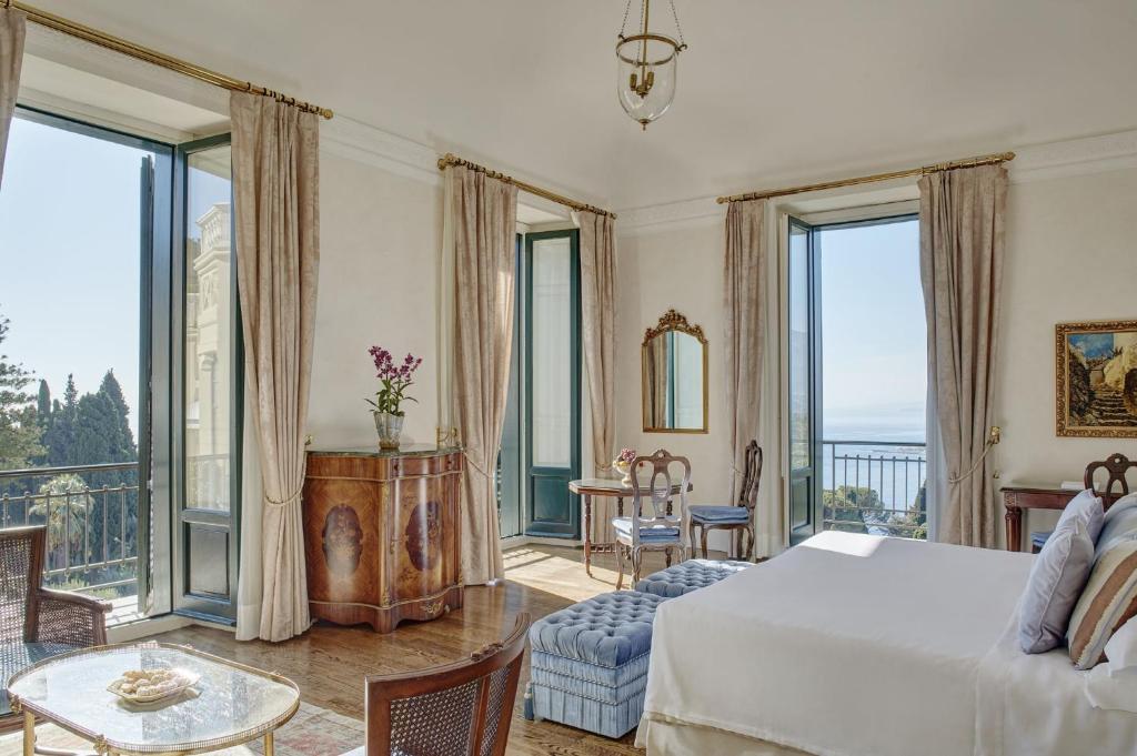 une chambre avec un lit et de grandes fenêtres dans l'établissement Grand Hotel Timeo, A Belmond Hotel, Taormina, à Taormine