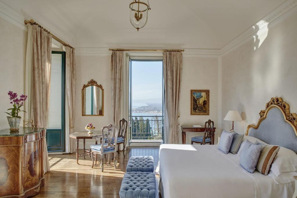 une chambre d'hôtel avec un lit et une grande fenêtre dans l'établissement Grand Hotel Timeo, A Belmond Hotel, Taormina, à Taormine 149 autres photos