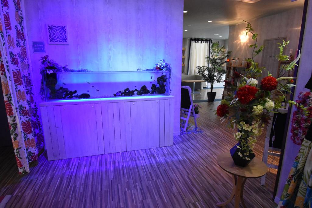 - un grand aquarium dans une chambre avec des lumières violettes dans l'établissement Hotel Melia RESORT(Adult Only), à Fuefuki