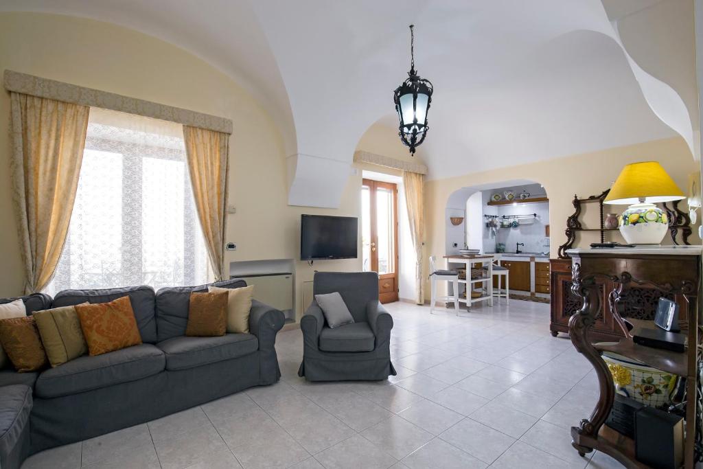 un salon avec un canapé et des chaises et une cuisine dans l'établissement Villa Elena, à Conca dei Marini