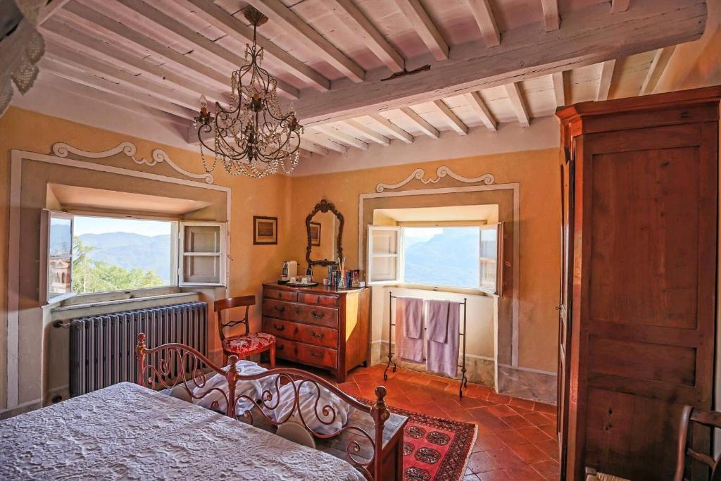 - une chambre avec un lit, une commode et des fenêtres dans l'établissement Villa Colletto, à Coreglia Antelminelli