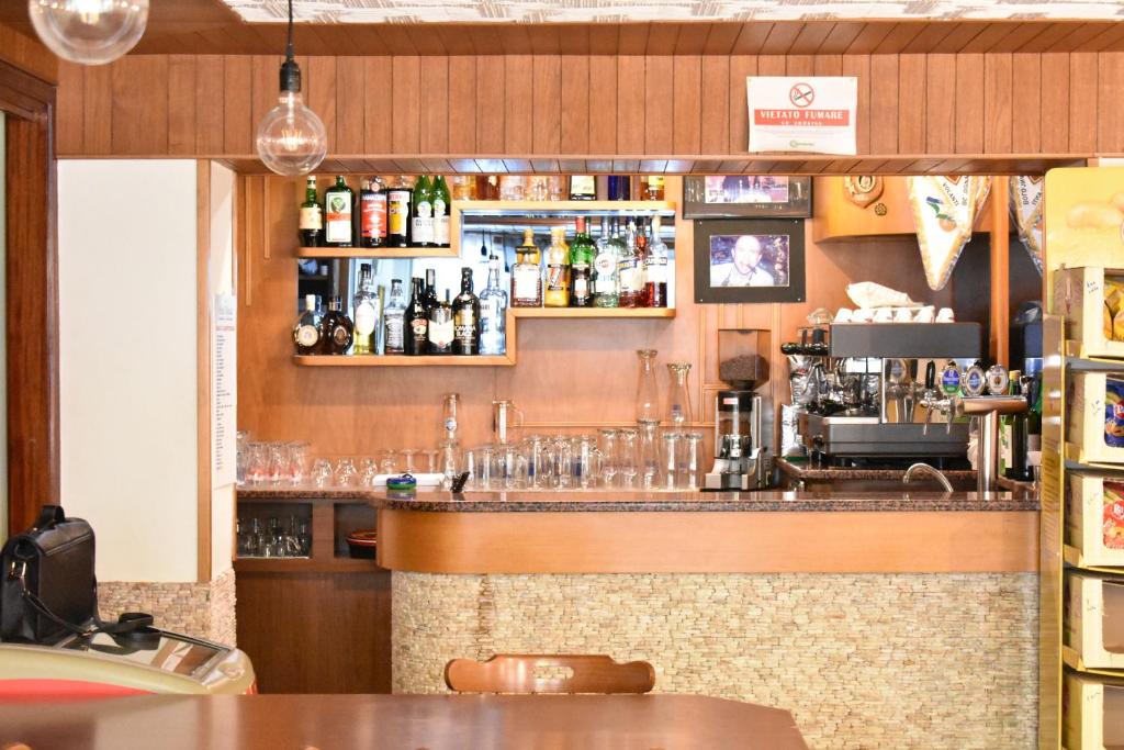 un bar dans un restaurant avec des bouteilles et des verres dans l'établissement Hotel Manila, à Cervia