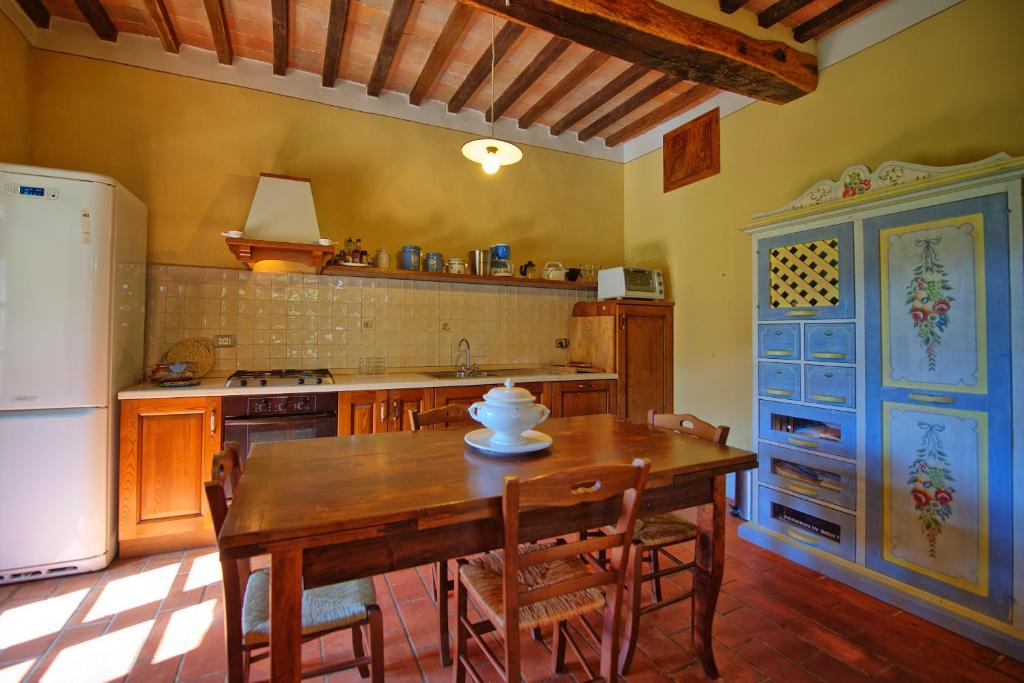 une cuisine avec une table en bois et un réfrigérateur dans l'établissement Poggiolino by PosarelliVillas, à Chitignano