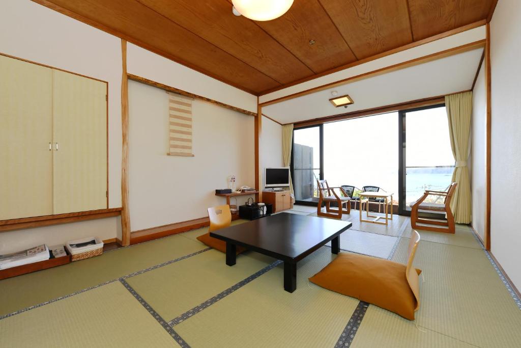 un salon avec une table et des chaises dans l'établissement Shimoda Yamatokan, à Shimoda