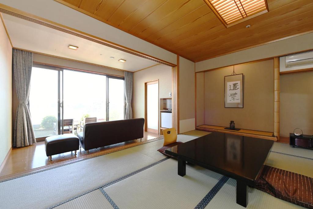 un salon avec un canapé et une table dans l'établissement Shimoda Yamatokan, à Shimoda