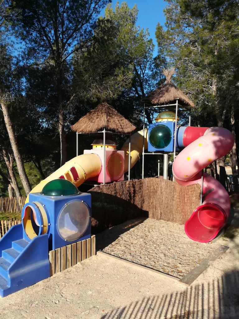 - une aire de jeux avec toboggan dans un parc dans l'établissement Camping Le Bois De Pins, à Salses-le-Chateau