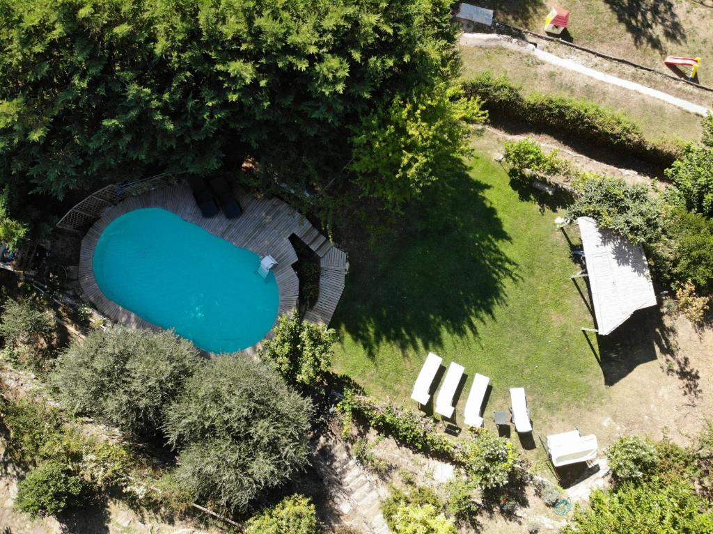 - une vue sur la piscine dans une cour avec des chaises blanches dans l'établissement Casa dei Ghiri, à Borgo San Lorenzo