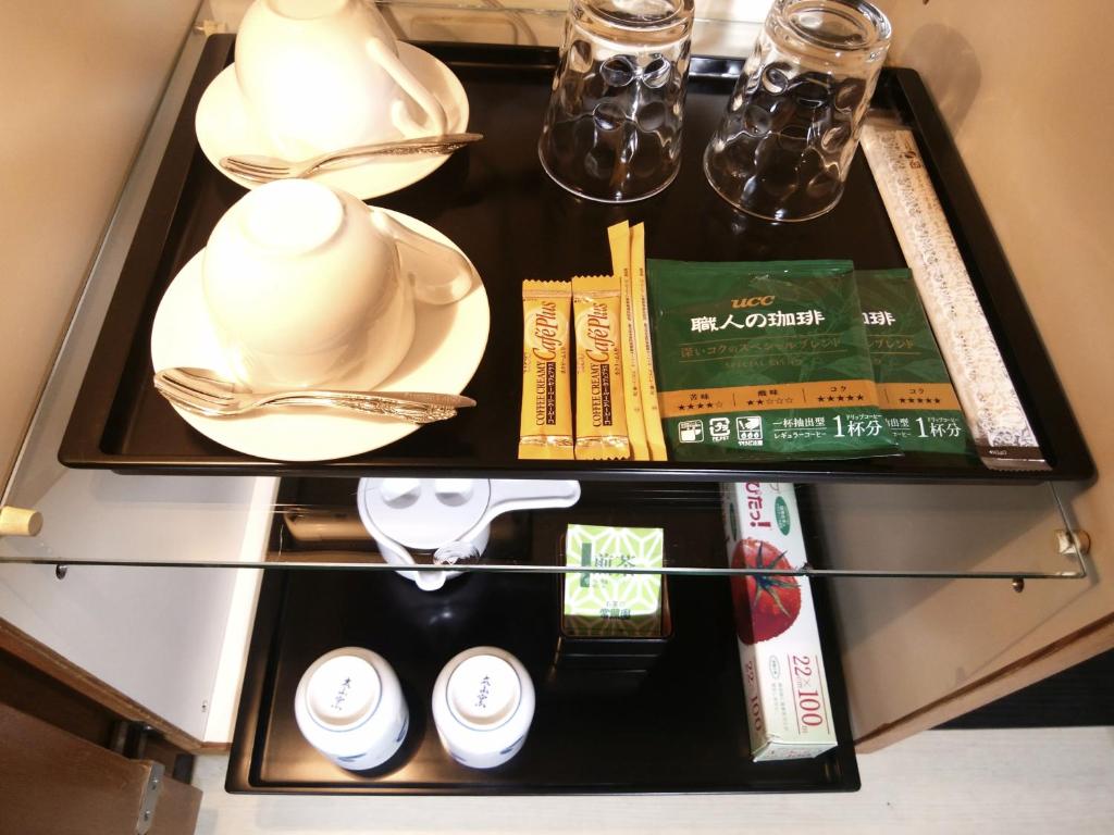 - une étagère avec de la vaisselle et d'autres articles dans l'établissement LA.FESTA (Adult Only), à Takamatsu