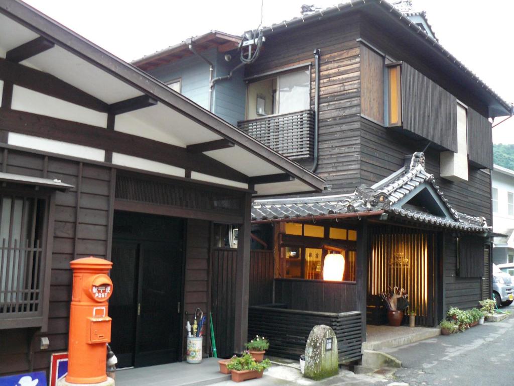 une maison avec un bâtiment de style asiatique et un portail dans l'établissement Ryokan Yamashiroya, à Yufu