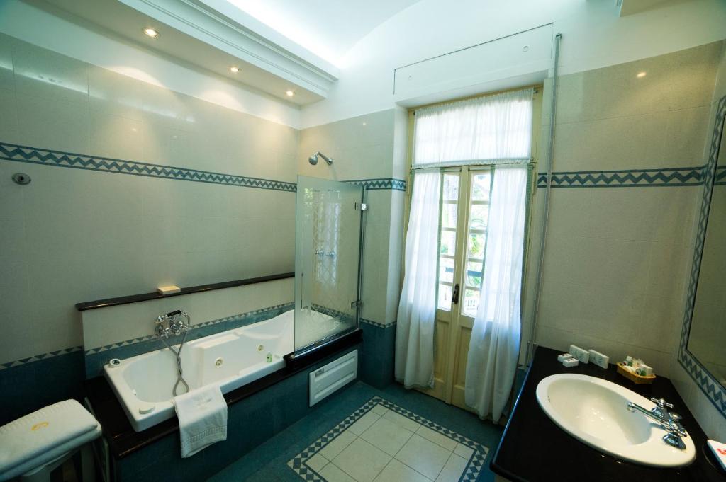 une salle de bain avec une baignoire et un lavabo et une baignoire dans l'établissement Grande Albergo Miramare, à Formia