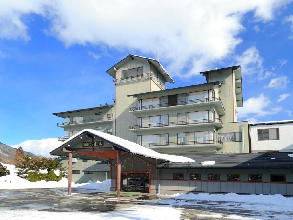 un grand bâtiment avec de la neige au sol dans l'établissement Kurobe View Hotel, à Omachi
