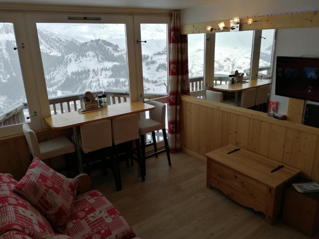 - un salon avec une table et une vue sur la montagne dans l'établissement Plagne AIME 2000 Ski Apartments, à Aime La Plagne