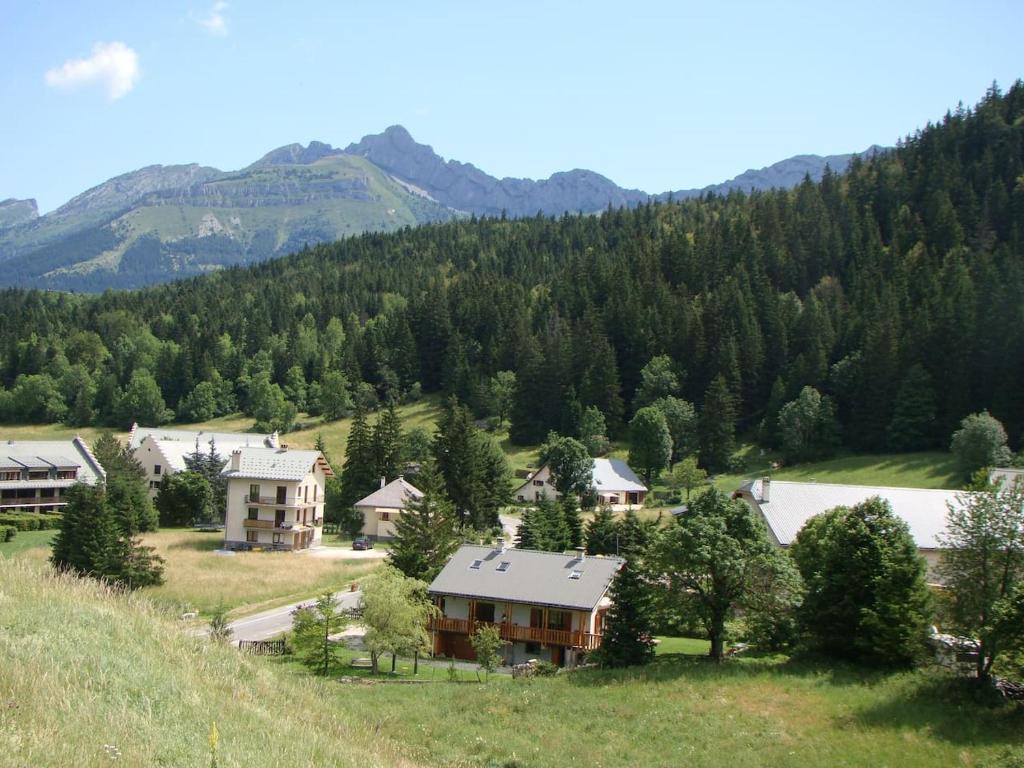 un village dans les montagnes avec des maisons et des arbres dans l'établissement Les Sens Ciel, à Corrençon-en-Vercors