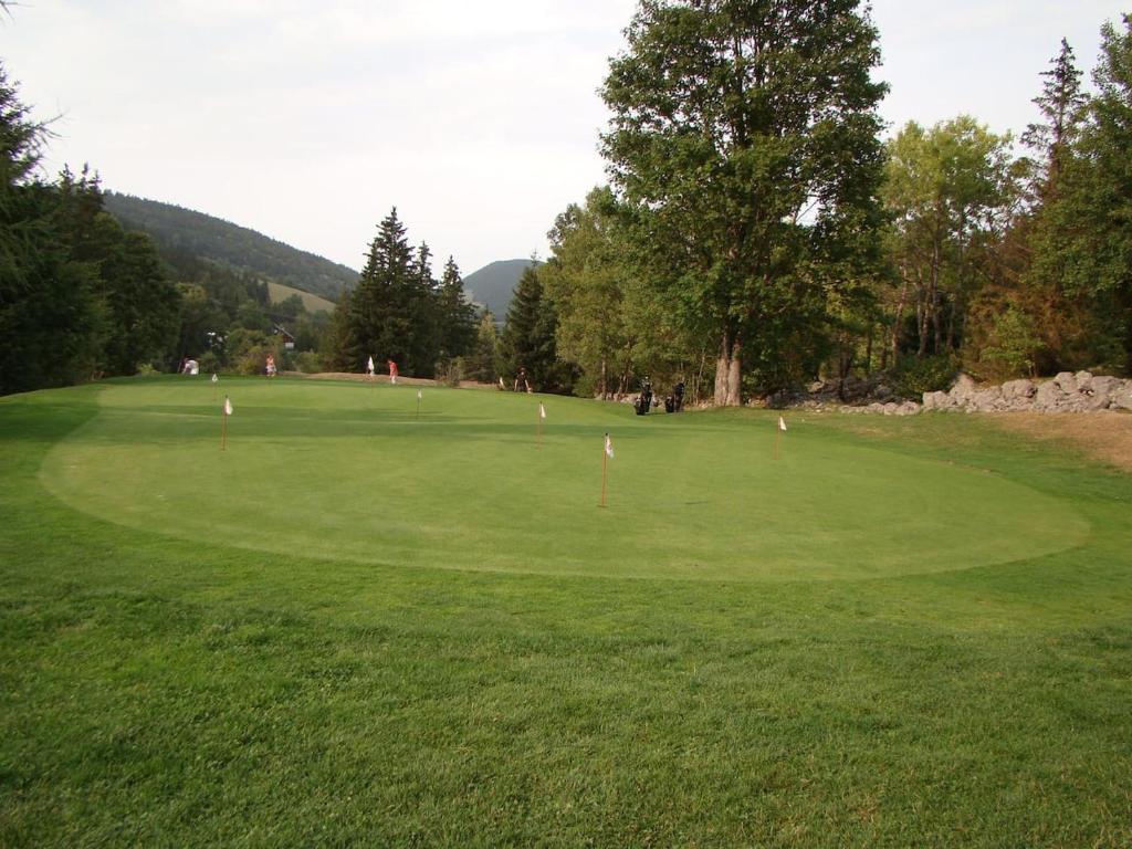 une vue d'un parcours de golf avec un green dans l'établissement Les Sens Ciel, à Corrençon-en-Vercors
