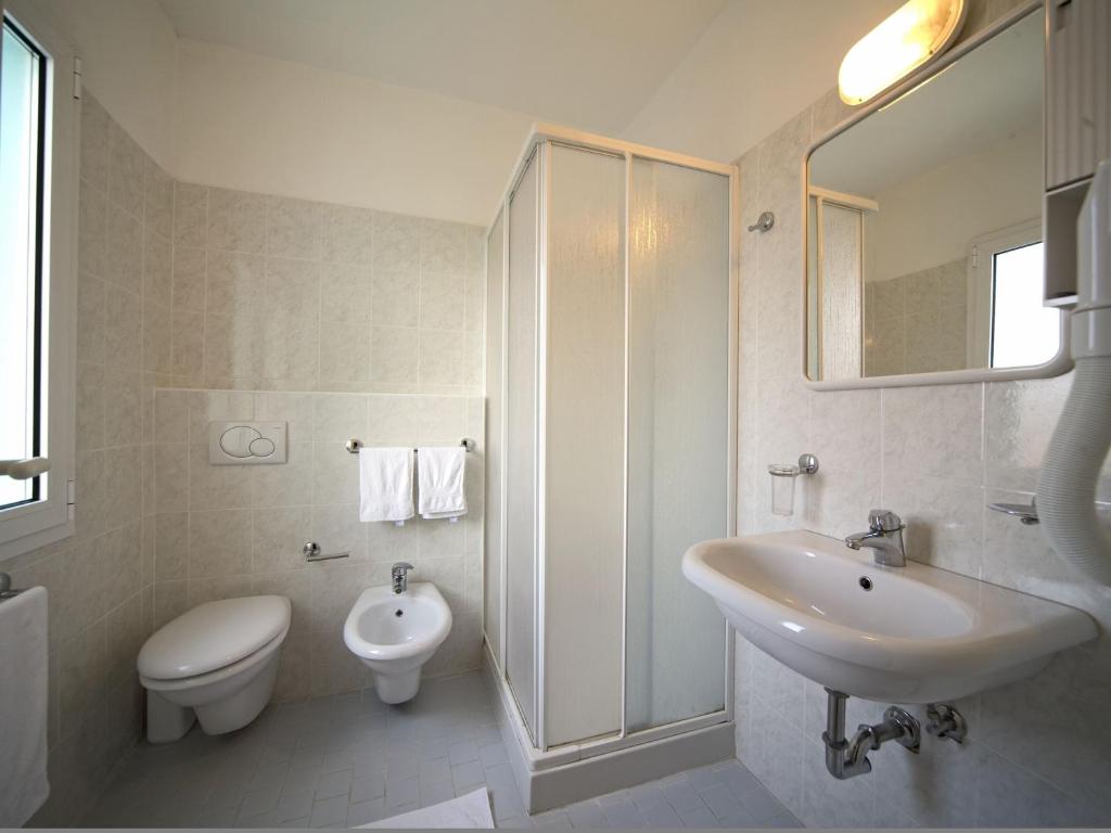 une salle de bain blanche avec un lavabo et des toilettes dans l'établissement Hotel Savina, à Rimini
