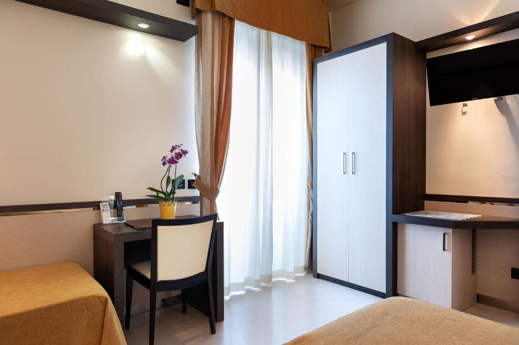 une chambre d'hôtel avec un lit, un bureau et une fenêtre dans l'établissement Hotel Mondial, à Porto Recanati