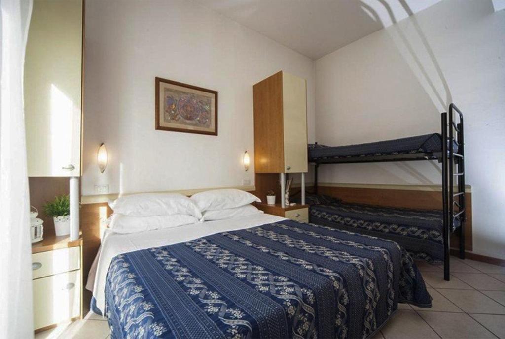 une chambre avec un lit et deux lits superposés dans l'établissement Hotel Jana, à Rimini