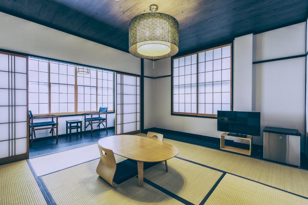 un salon avec une table et une télévision dans l'établissement Ogawa Ryokan, à Shimoda