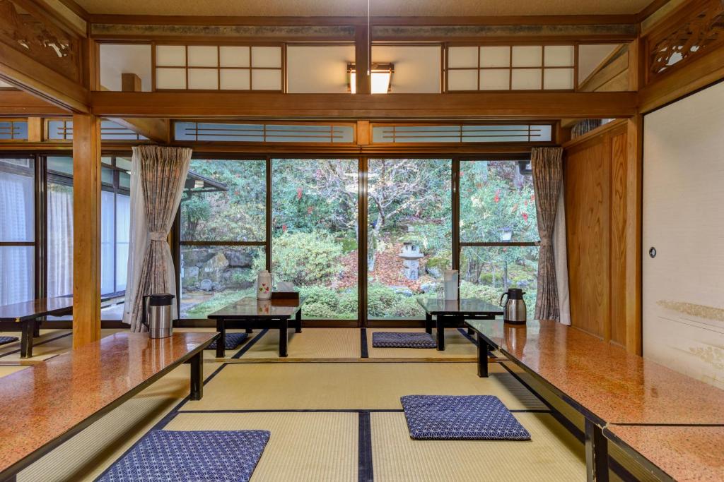 - une salle de méditation avec des matelas bleus devant une grande fenêtre dans l'établissement Kyo no Minshuku Ohara no Sato, à Kyoto