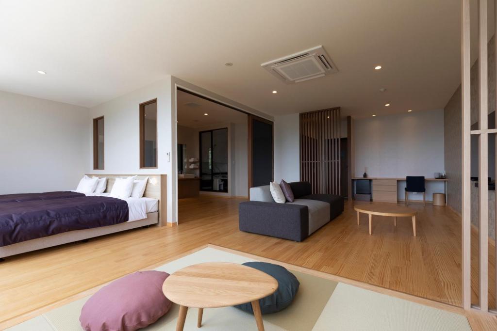 une chambre avec un lit, un canapé et une table dans l'établissement 宮島離れの宿 IBUKU -Miyajima Hanare no Yado IBUKU-, à Miyajima